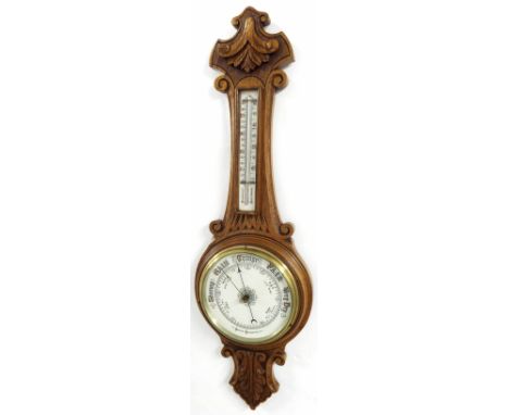 Oak aneroid barometer/thermometer, the 8" cream dial within a foliate carved case