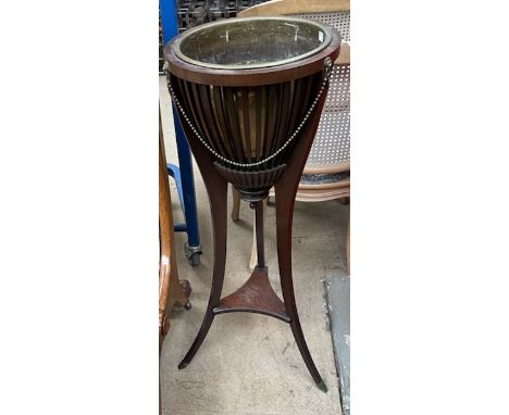 A mahogany jardiniere with a brass inset and stick sides on three splayed legs