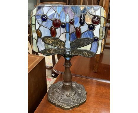 A Tiffany style lamp with a dragonfly decorated shade and base 