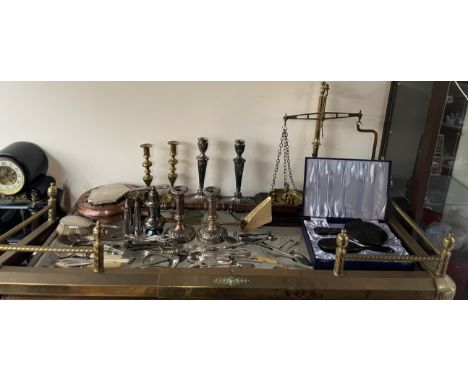 A brass fire fender together with a copper bedwarming pan, brass scales, electroplated flatwares, candlesticks, sugar sifter,