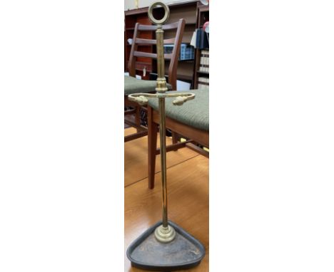 A brass and cast iron stick stand, with scrolling arms and a triangular base 