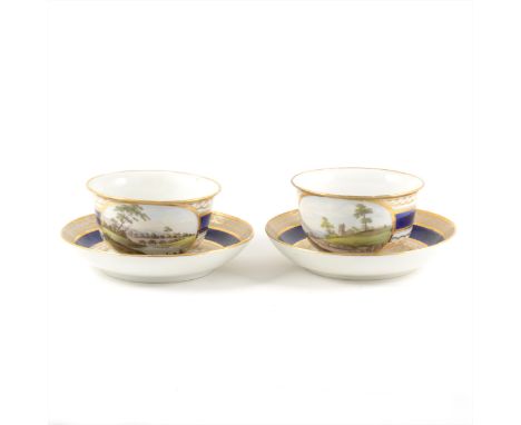 A pair of Derby style porcelain breakfast cups and saucers, with named views, Nr Caernarfon, South Wales, and on the River To
