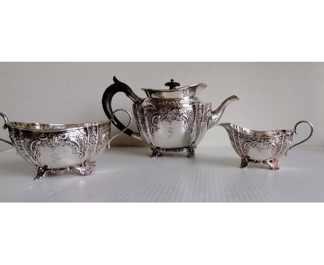 A late Victorian silver three-piece bachelor tea service with embossed rococo decoration, initialled, by Fenton Brothers Ltd.