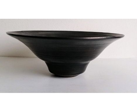 An iridescent black circular bowl, 7 x 18 cm, incised studio stamp to base for Dame Lucie Rie, without visible damage or repa