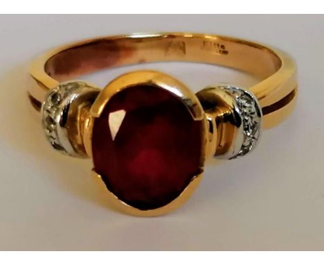 A gold and ruby ring with diamond decoration to shoulders, the oval ruby 8x6mm, testing for high quality gold, stamped Elite 