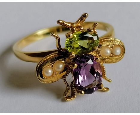 A Suffragette ring with peridot, amethyst and seed pearl decoration in the shape of a bumblebee on a silver-gilt setting, siz