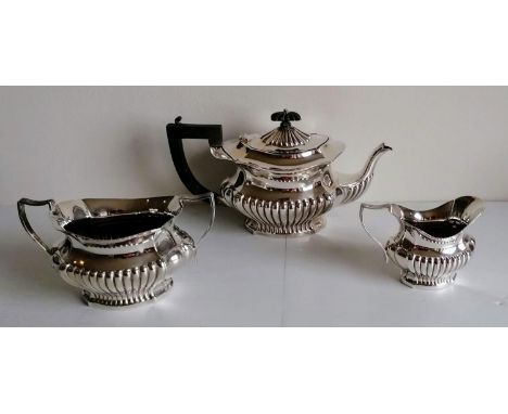 An Edwardian-style three-piece silver plated tea service with half-fluted design, ebony knop and handle and other silver plat
