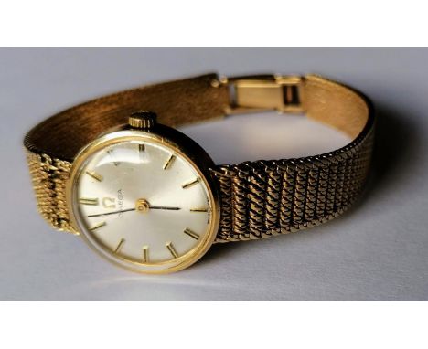 A mid-century ladies Omega manual watch with baton markers, 9ct gold case and mesh strap (kink to strap, see photo), hallmark