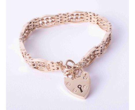 A 9ct yellow gold with an ornate gate design bracelet with heart padlock &amp; safety chain, 22g.