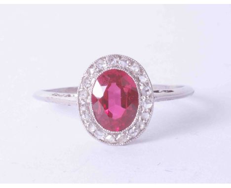 A platinum cluster ring set oval ruby approx. 0.65 carat, surrounded by diamonds in a milgrain setting, finger size O.