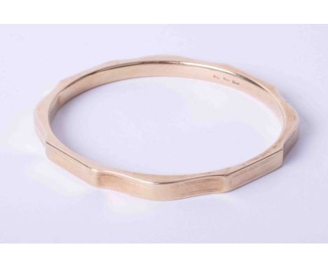 A 9ct yellow gold hollow hexagonal slave bangle with engraving to the outer edges, 19.9g.