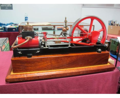 A Horizontal Steam Engine, length 12 inches, 7 inch diameter flywheel, 2 inch stroke, finished in red and bright metal, mount