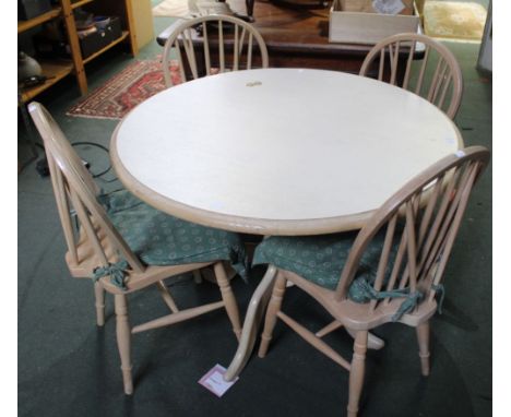 A modern circular kitchen table and four stick back chairs