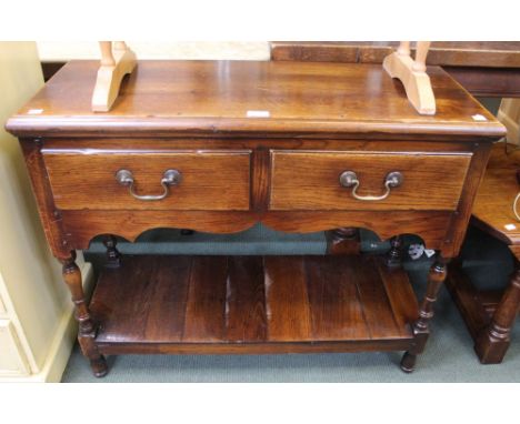 A reproduction oak Georgian style low boy with two drawers and under tier shelf