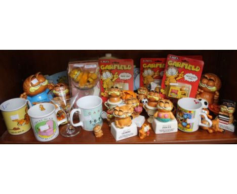 A shelf containing a selection of Garfield collectibles, ceramics a wall hanging watch etc&nbsp;