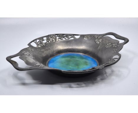 An Archibald Knox for Tudric Pewter twin handled bowl, the body pierced and with shamrock design, with central green to blue 