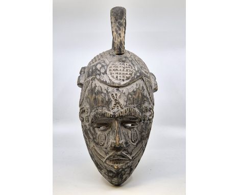 Ethnographica: Three West African carved wood tribal masks, 20th century, the longest a wall hanging mask with painted decora