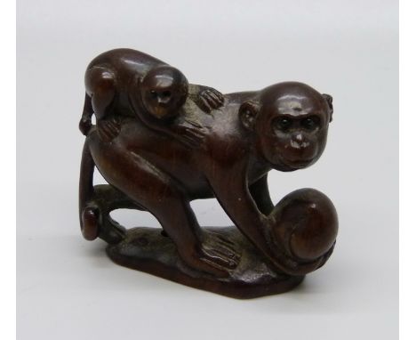 A carved rosewood netsuke of two monkeys, signed on the base 