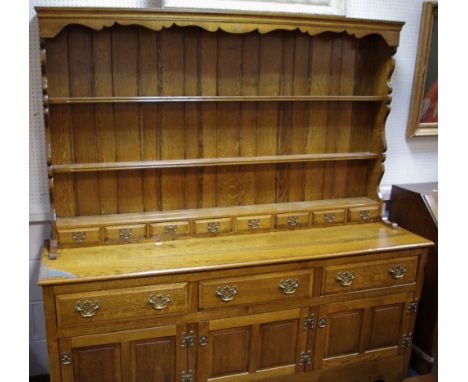 A large country oak dresser, shaped uprights, three shelves and eight small drawers to superstructure, three short drawers ov