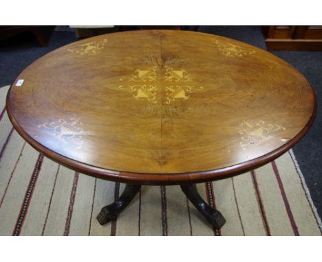 A Victorian mahogany loo table, oval top inlaid with urns and scrolls, five turned columns to base, four cabriole legs, ceram