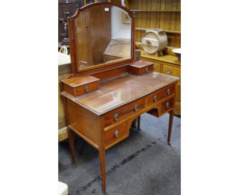 An Edwardian mahogany dressing table, arched bevel edge mirror, spreading square supports and two small drawers to top, two l