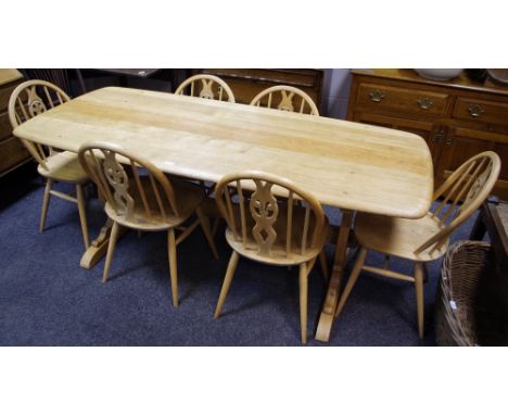 An Ercol stripped oak refectory style table, six Ercol fleur de lys pattern elm dining chairs (7)