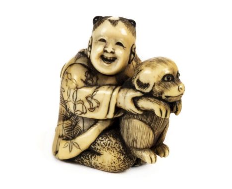 * Netsuke. A fine Japanese Meiji period ivory netsuke, carved as a boy holding a dog, with paper label to the foot, 4 cm high