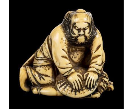 * Netsuke. A fine Japanese Meiji period ivory netsuke, carved as man holding a horn kneeling by a nut, signed, 4cm high, toge