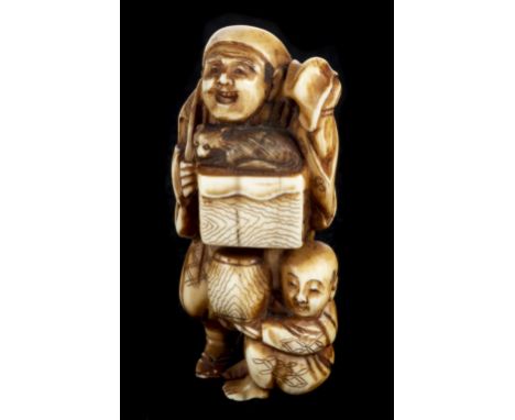 * Netsuke. A fine Japanese Meiji period ivory netsuke, carved as a street seller holding a box with a cat and boy beneath hol