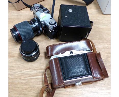 A Canon AE1 SLR camera with 2 lenses; an Agfa Isolette; and a box Brownie