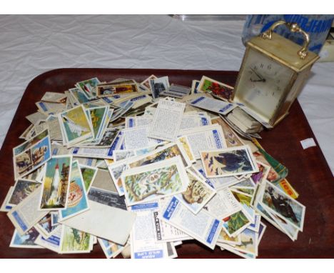 A modern wall clock; a carriage clock and a quantity of cigarette cards