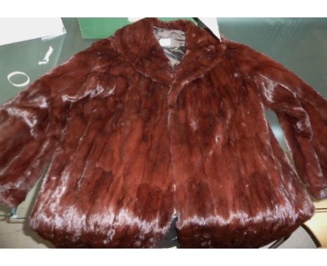 An early/mid-20th century russet coloured full length fur coat; a brown three quarter length fur coat; a light brown three qu