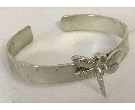 A 925 silver bangle with dragonfly detail to front.  Dragonfly set with central clear stone.  Total weight approx. 21 g.