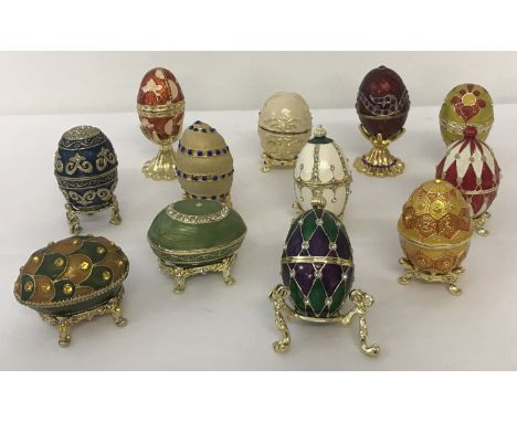 A collection of 12 enamelled and stone set egg shaped trinket pots on stands.  From Atlas Editions "History of the Faberge Eg