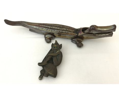 A vintage nutcracker in the shape of a crocodile.  Together with a brass pixie door knocker. 