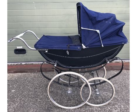 A vintage full-sized Silver Cross The London Baby Coach pram in navy blue with hood and apron. Some wear to tyres. Together w