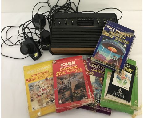 A vintage Atari Video computer console together with 5 games.  To include "Space Invaders". 