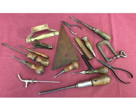 A tray of assorted small vintage hand tools.  To include: a brass mitre square, an "Eezit" stretcher, ebony handled button ho