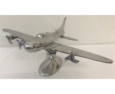 A large aluminium desktop model of a 4-engined bomber aircraft. On a felt-lined pedestal base.  Propeller's spin. Approx. 22c