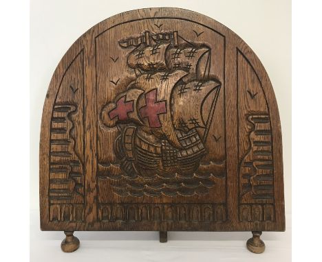 A vintage oak curve topped fire screen with carved galleon design to front on bun feet.   Approx. 70cm tall x 68cm wide.