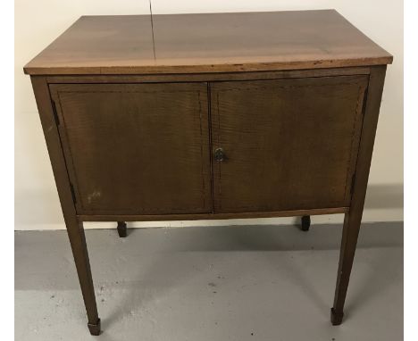 A vintage satin wood 2 door cupboard with interior shelf.  Beaded inlay detail to front doors. Tapered legs with spade feet. 