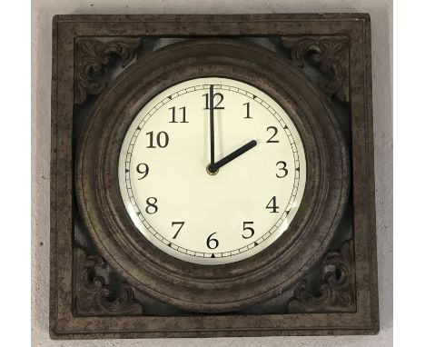 A cast iron framed wall hanging garden clock with classic decoration.  Battery operated.  Approx. 35.5cm x 35.5cm.