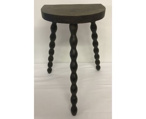 A dark wood stool with tripod bobbin style legs.   Approx. 46cm tall.