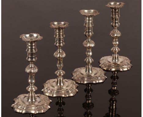 A matched set of four George II cast silver candlesticks, two by Gabriel Sleath, London 1753, another James Gould, London 174