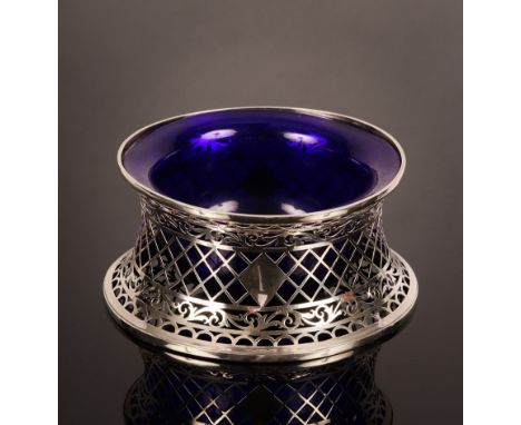 A silver dish or potato ring, Nathan & Hayes, Chester 1913, with pierced sides and a fitted blue glass liner, 21cm diameter, 