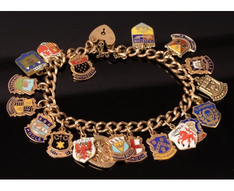 A 9ct gold curb link charm bracelet, hung with a wide array of mainly 9ct gold and enamel shields for various towns, approxim