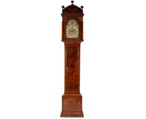 An early Georgian walnut longcase clock with caddy top hood surmounted by turned ball finials, moulded cornice above a blind 