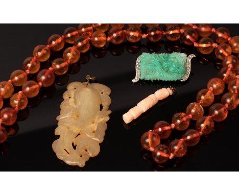 A carved jade pendant modelled as a gourd among leaves, 6.5cm long, a carved coral pendant of standing figure form, 4cm long,