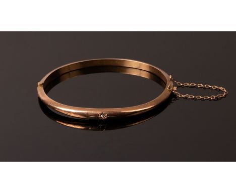A 9ct rose gold hinged bangle, gypsy set with a small diamond, internal measurement 5.5cm x 5cm, approximately 5.8g CONDITION
