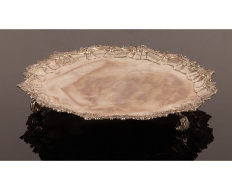 A George II silver salver, W K, London 1744, with pie crust border and shell and scroll rim on scroll feet, crested, 28.5cm w